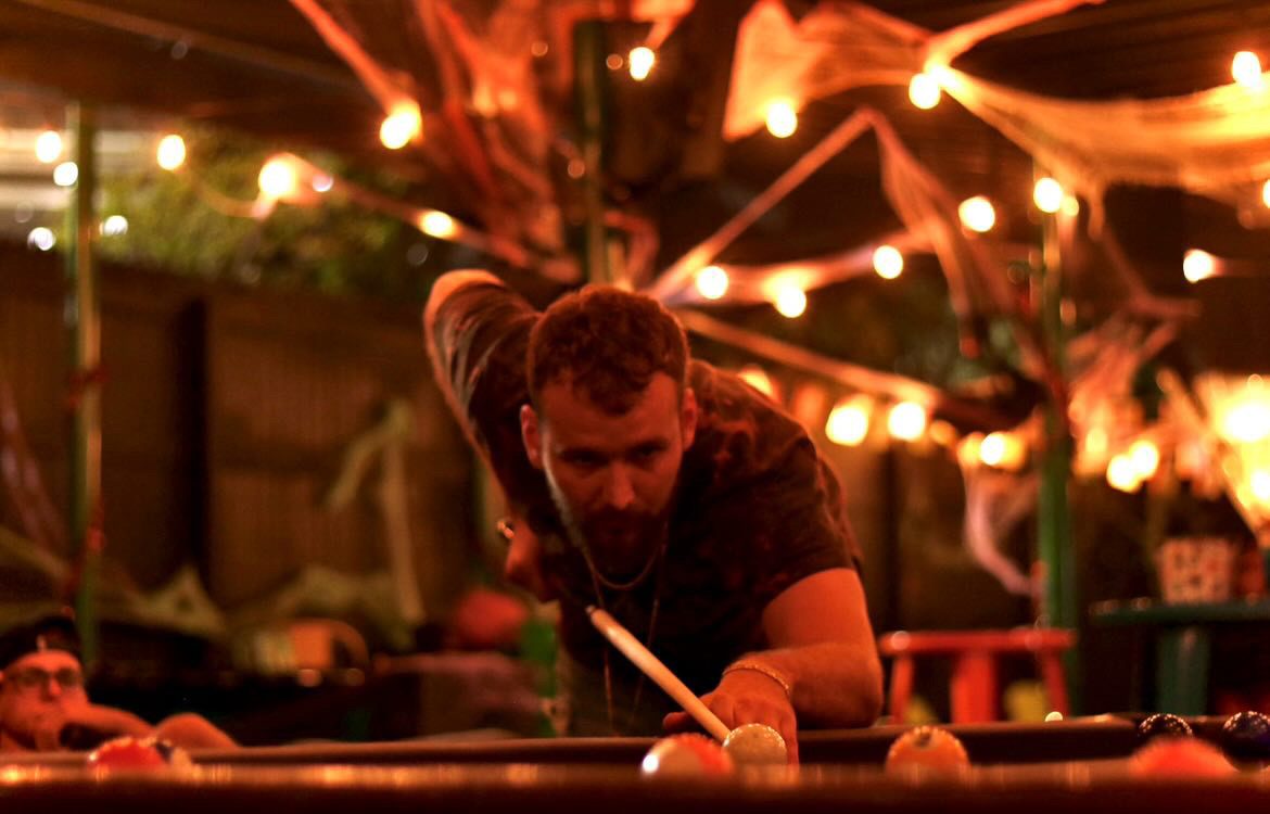 Bartender pouring a drink behind the bar at Kava & Company